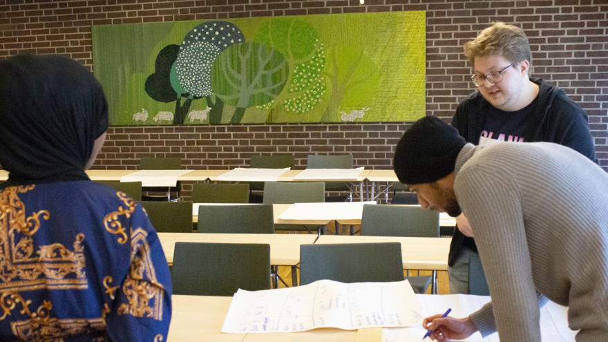 Ubah, Ludde och Mostafa planerar månadens aktiviteter tillsammans.