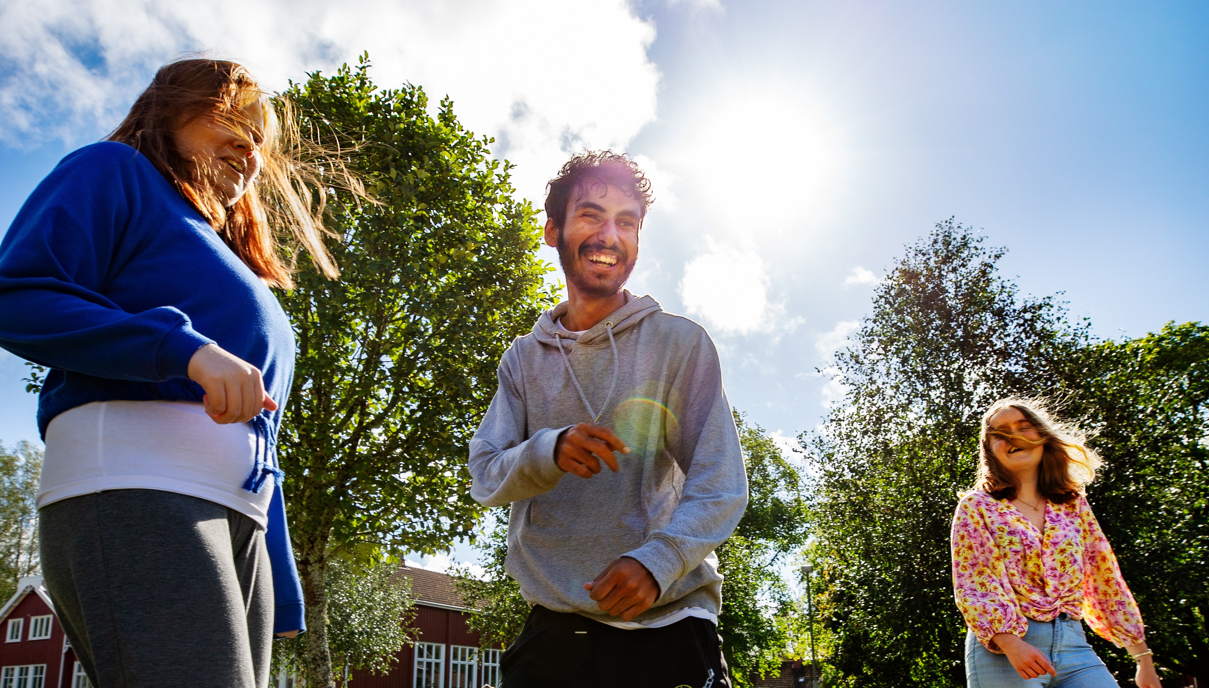 Tre personer som skrattar utomhus