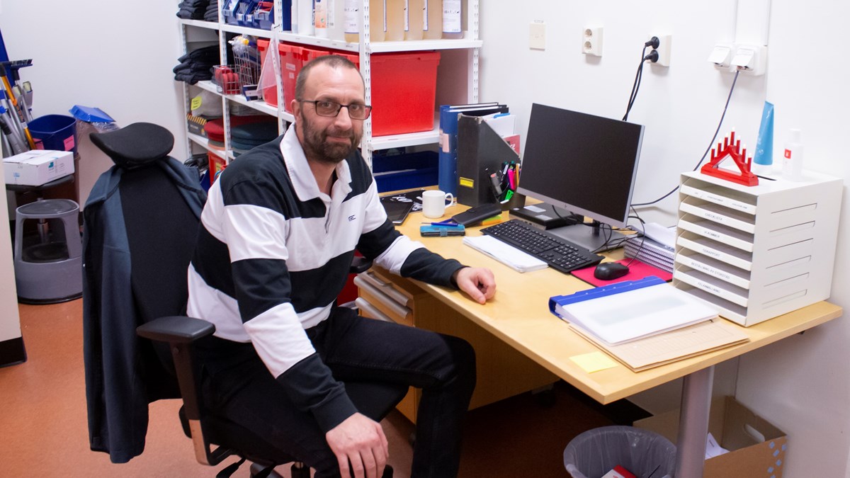 Patrik Apell, Jobbspår Regionservice, sitter vid ett skrivbord med en dator och kontorsmaterial.