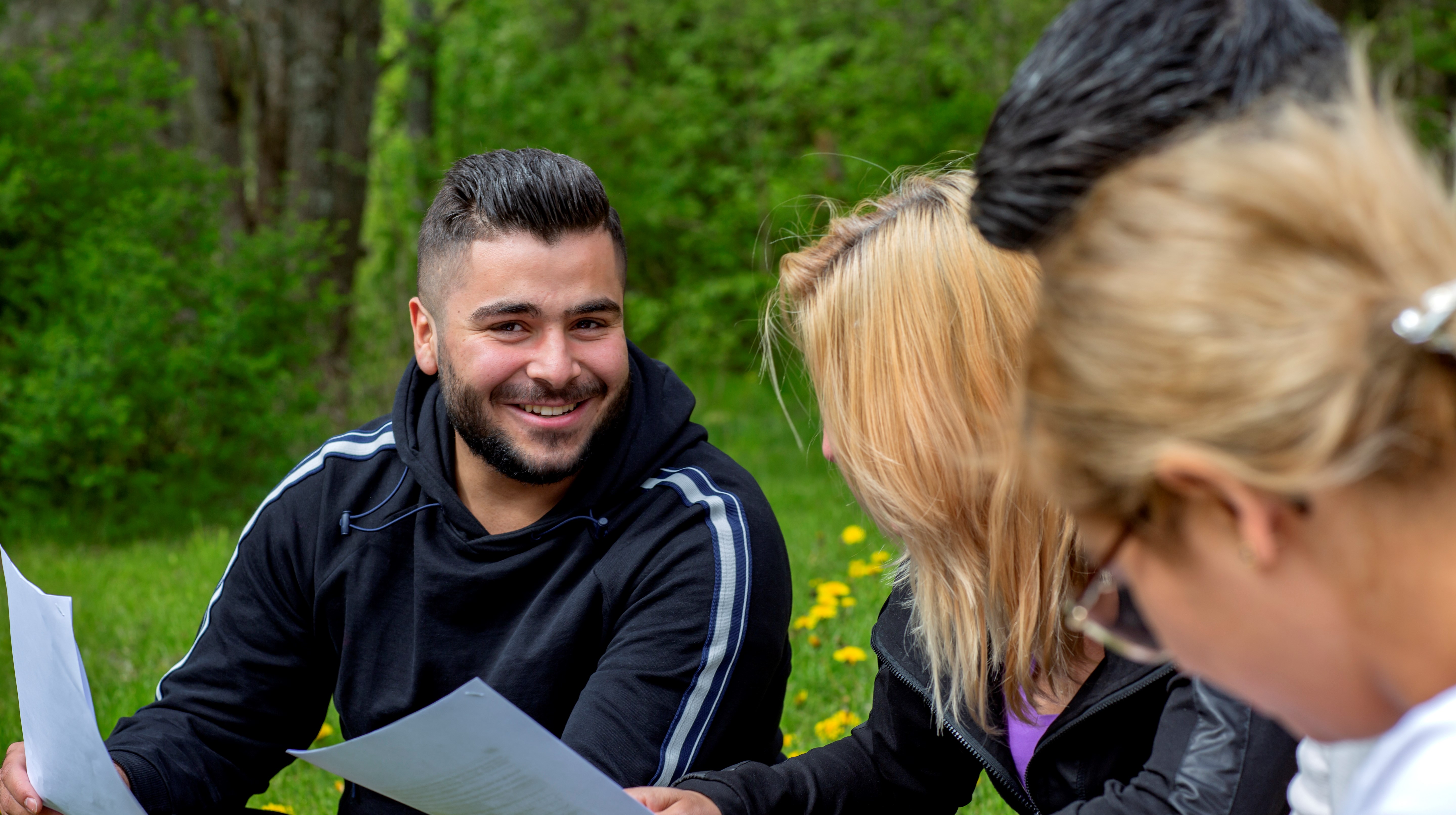 Tre deltagare läser i papper.